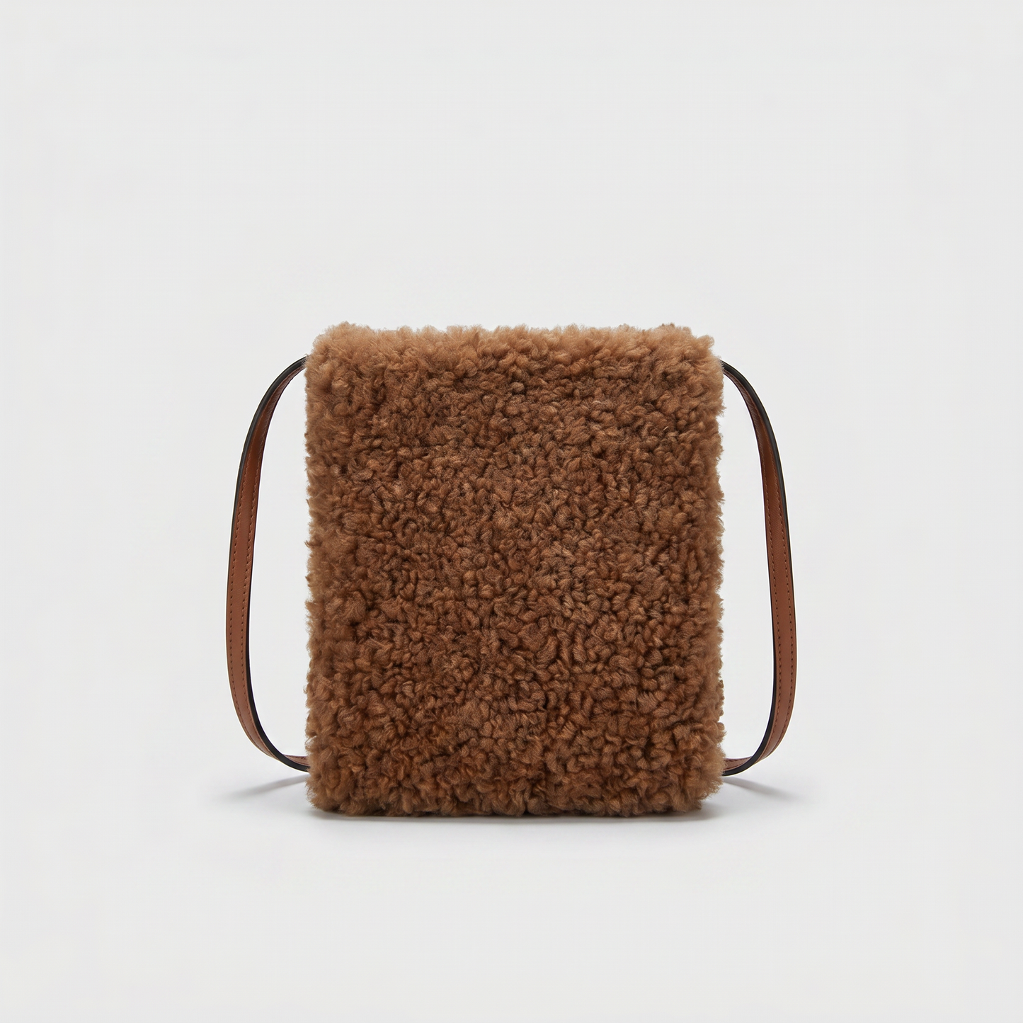 Pia faux shearling crossbody bag in Mocha on light grey studio background