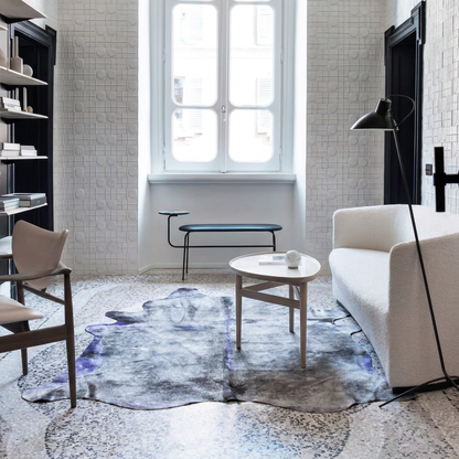 Grey and violet metallic cowhide rug styled on decorative pale terrazzo in a minimal contemporary sitting room