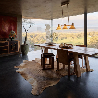 Caramel and ivory exotic printed cowhide rug styled on the floor of an editorial interior