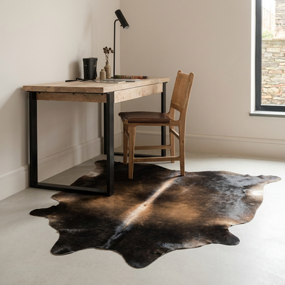 Natural cowhide rug styled on the floor of an editorial interior room