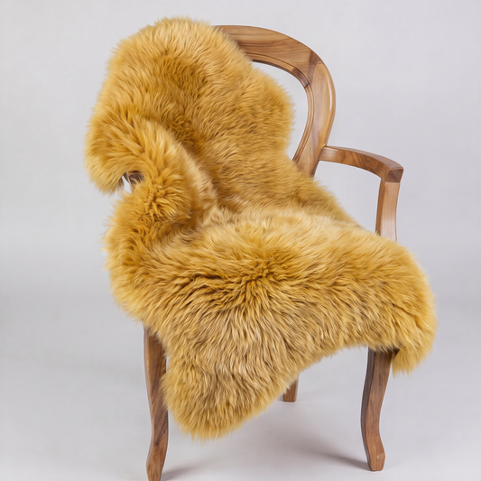 Squash golden sheepskin rug draped over a wooden armchair, front three-quarter view
