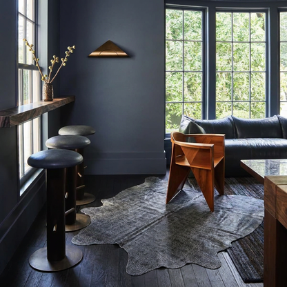 Charcoal snakeskin-embossed cowhide rug styled on the dark wood floor of a moody luxe charcoal den