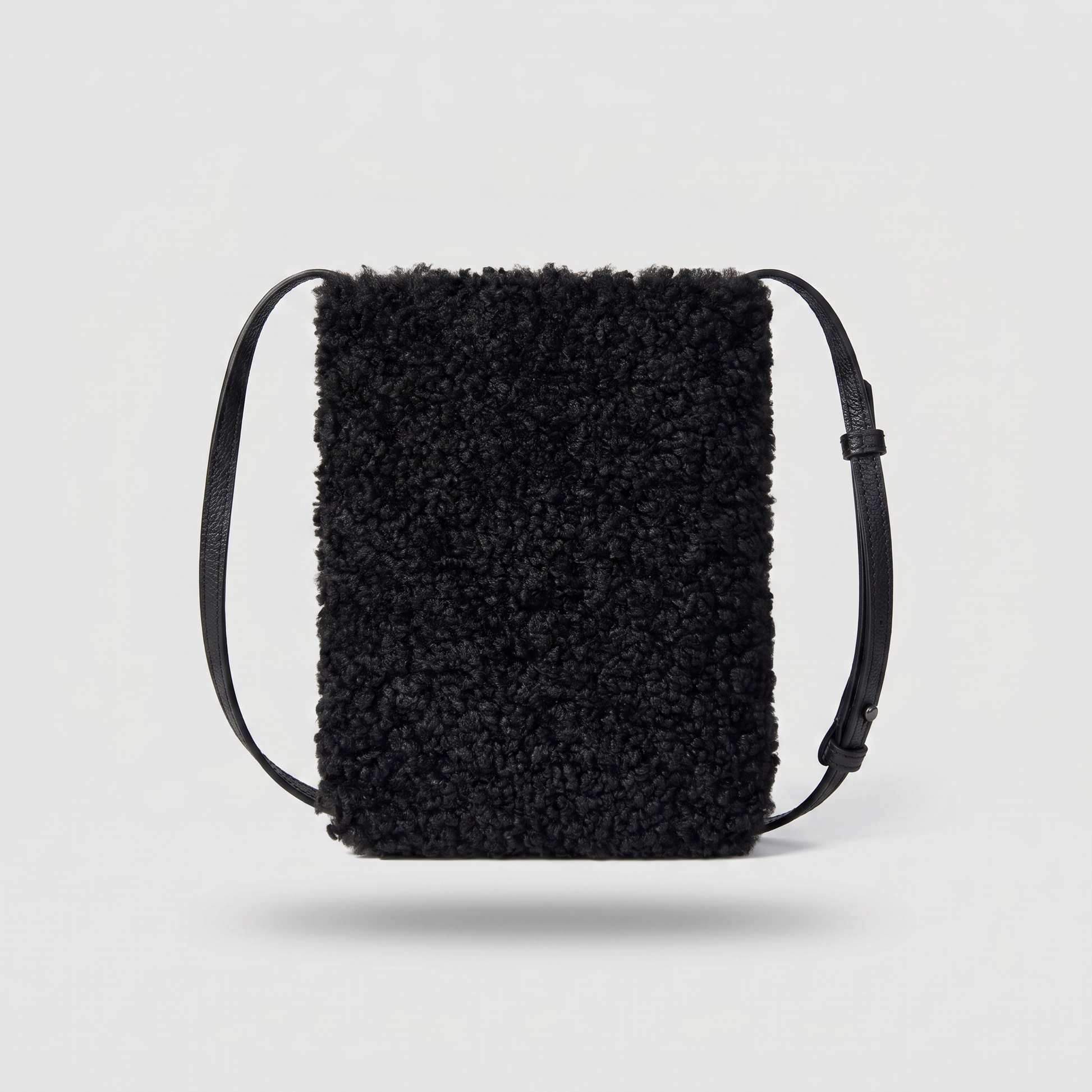 Pia faux shearling crossbody bag in Black on light grey studio background