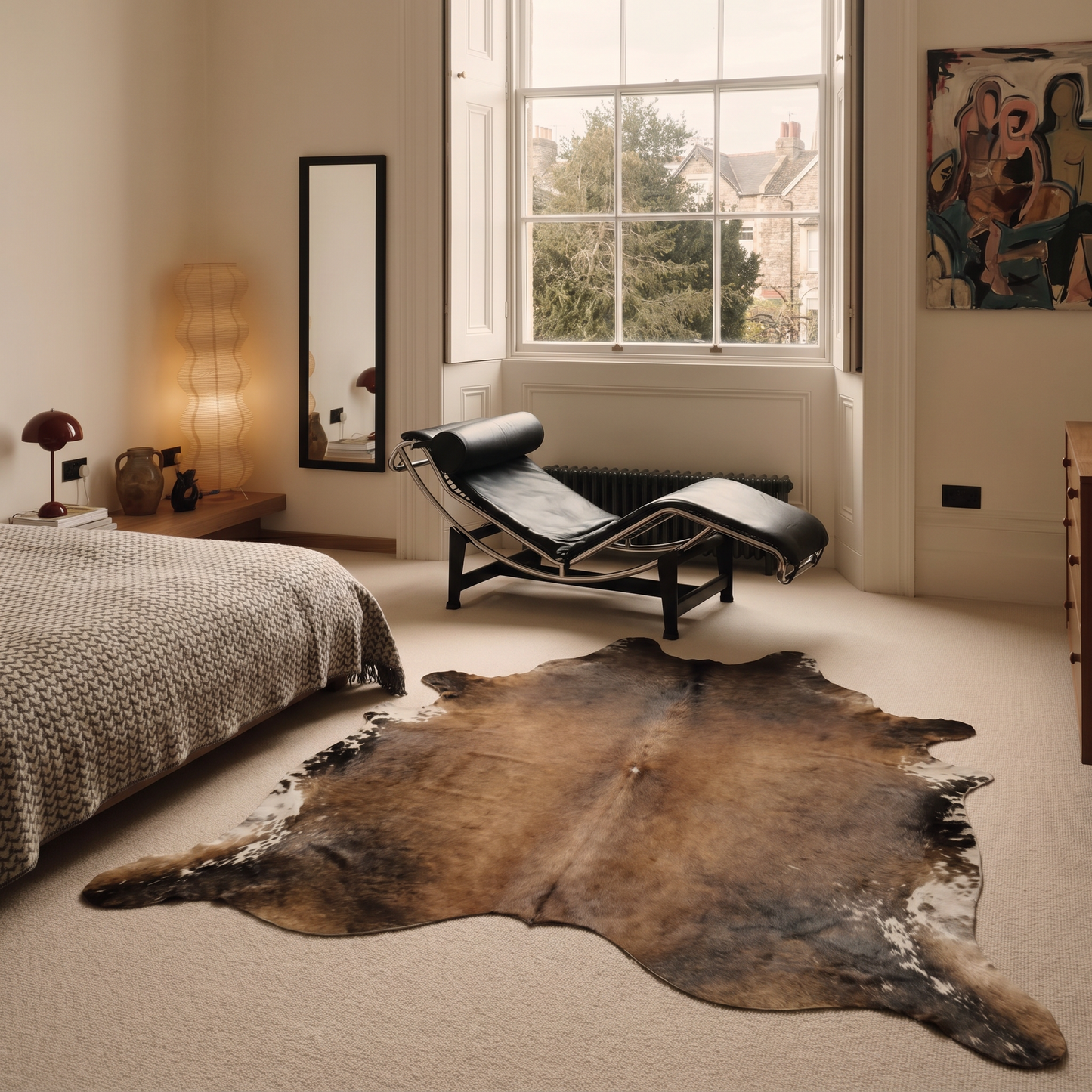 Mocha, chocolate and ivory cowhide rug styled on the floor of an elegant Georgian bedroom