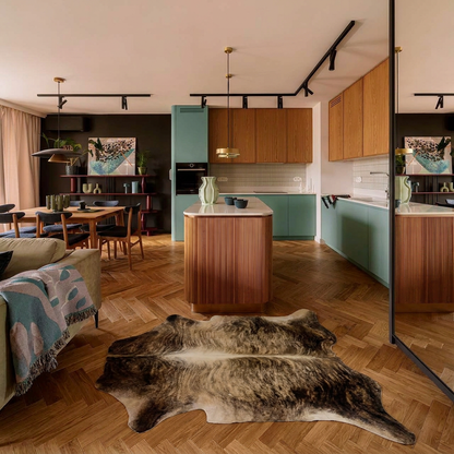 Exotic brindle cowhide rug styled on the herringbone floor of a warm mid-century kitchen and dining room