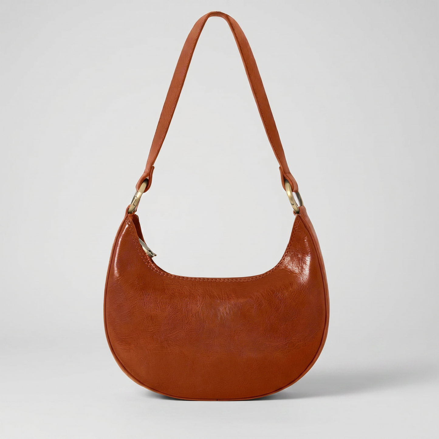 Mezzaluna leather shoulder bag in Tan on light grey studio background