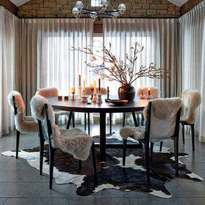 Caramel and ivory exotic printed cowhide rug styled on the floor of an editorial interior