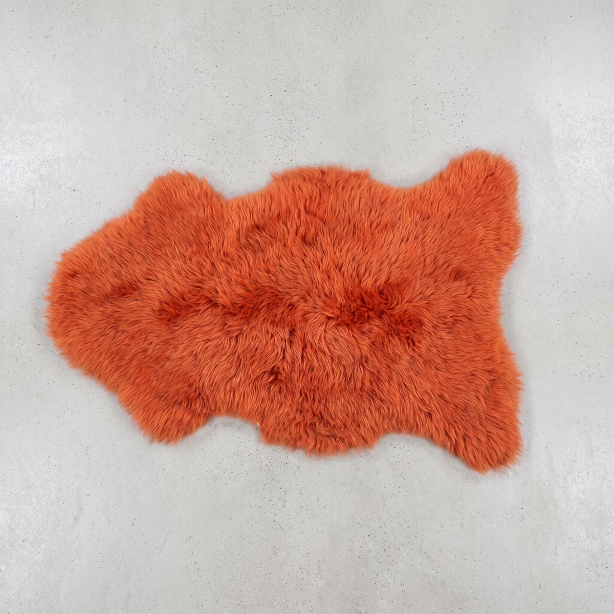 Burnt Orange single sheepskin pelt flat-lay on a pale grey floor