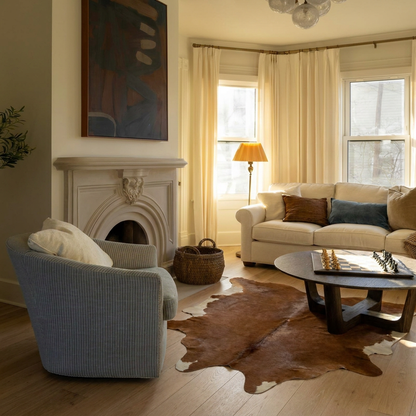 Caramel and ivory exotic printed cowhide rug styled on the floor of an editorial interior