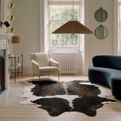 Natural cowhide rug styled on the floor of an editorial interior room