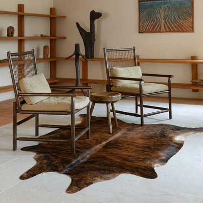 Dark brindle cowhide rug styled on the floor of an editorial interior