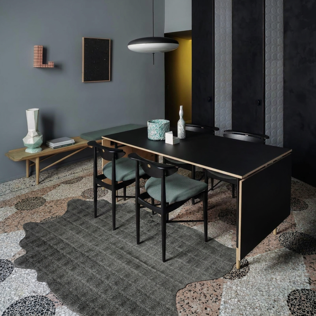 Charcoal snakeskin-embossed cowhide rug styled on the terrazzo floor of a moody luxe grey-green dining room