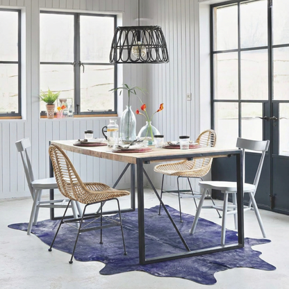 Purple metallic cowhide rug styled on the floor of a white-panelled Scandinavian dining room