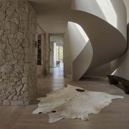 Caramel and ivory exotic printed cowhide rug styled on the floor of an editorial interior