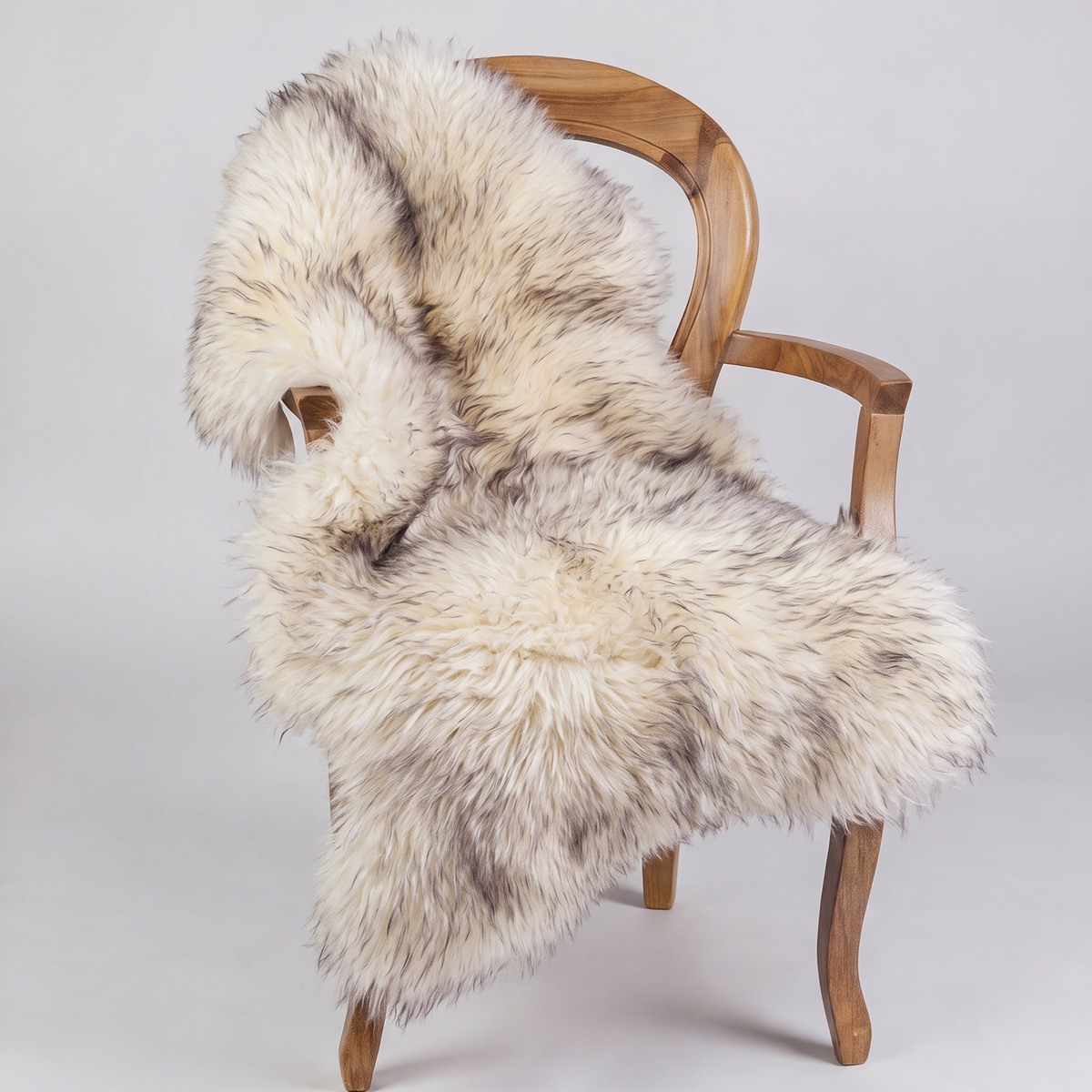 Twilight sheepskin rug draped over a wooden armchair, front three-quarter view