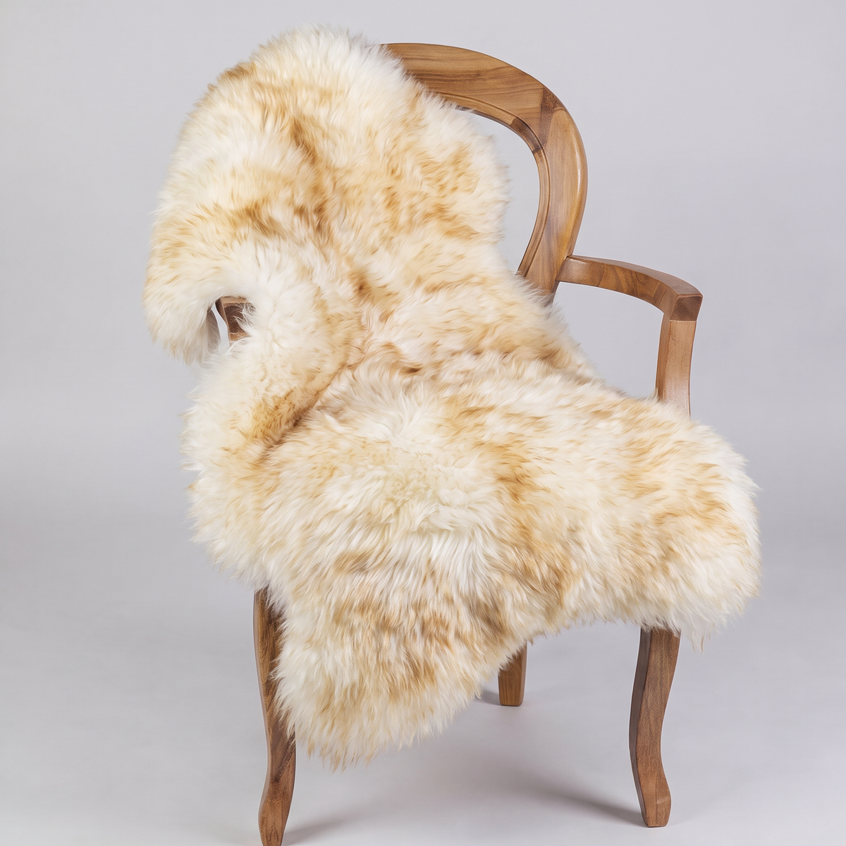 Dusk sheepskin rug draped over a wooden armchair, front three-quarter view