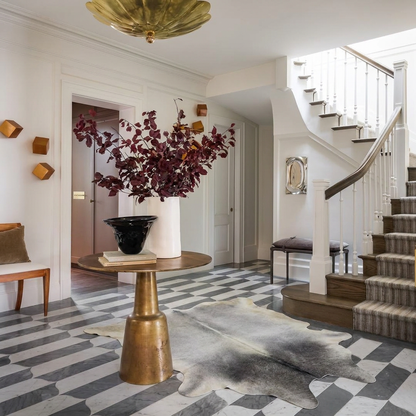 Grey cowhide rug styled on the marble tile floor of an elegant cool-toned entryway