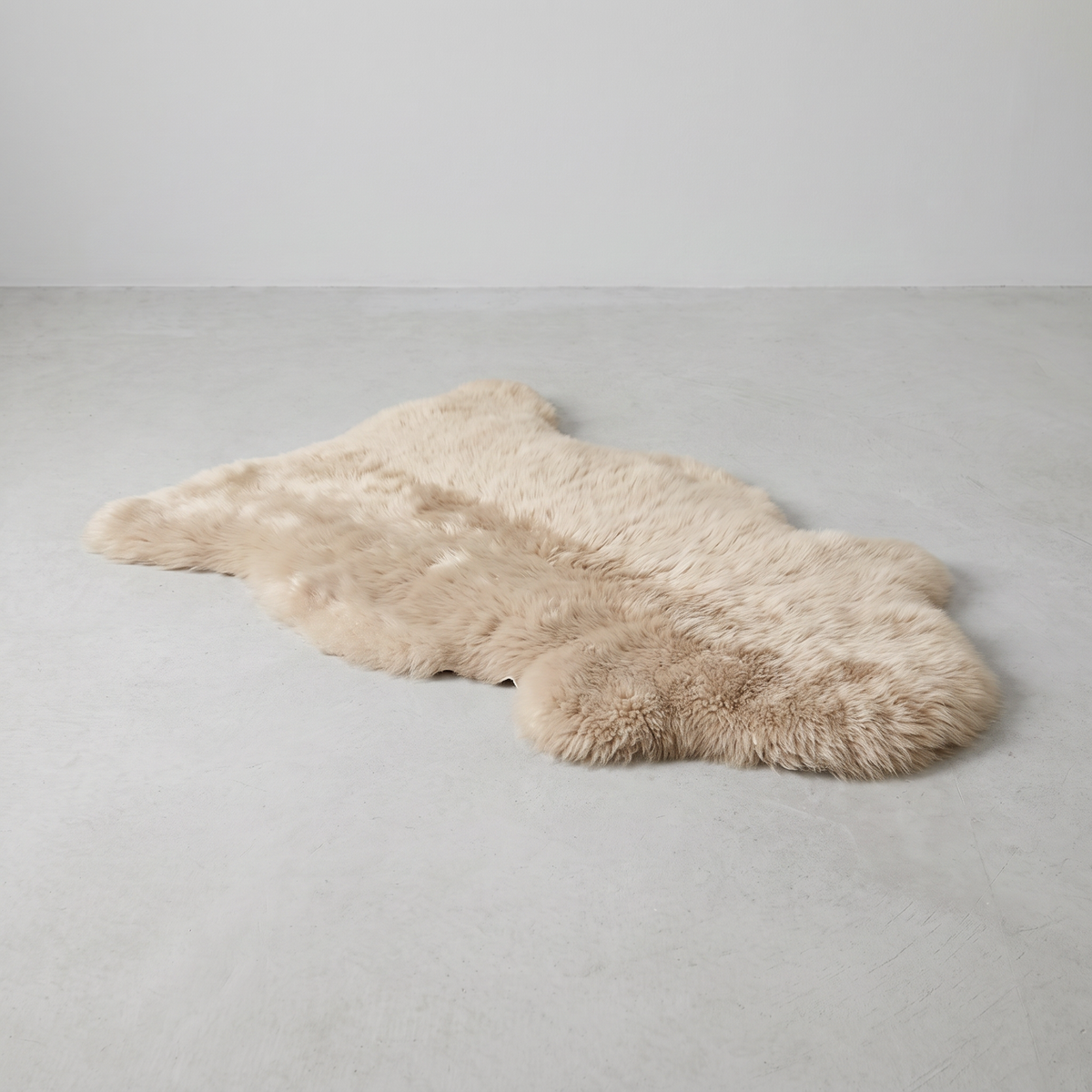 Oyster single sheepskin rug laid flat on a pale grey floor
