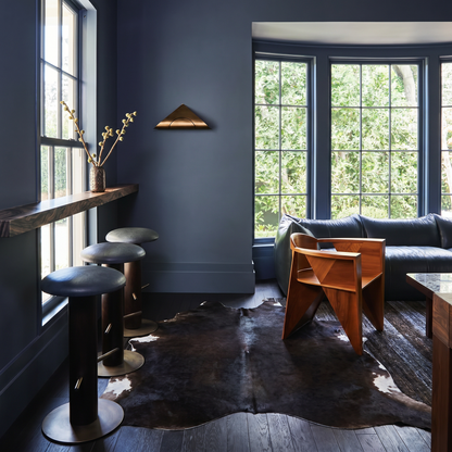 Espresso solid cowhide rug styled on the floor of a moody dark blue living room