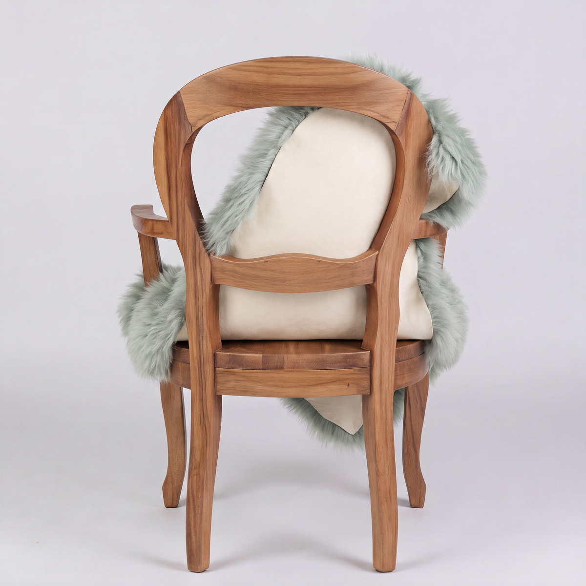 Sage green sheepskin over an armchair back, suede leather underside facing the camera