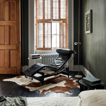 Caramel and ivory exotic printed cowhide rug styled on the floor of an editorial interior