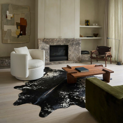Natural cowhide rug styled on the floor of an editorial interior room