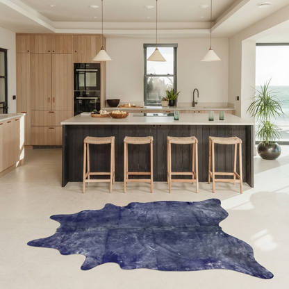Purple metallic cowhide rug styled on the pale limestone floor of a warm contemporary kitchen