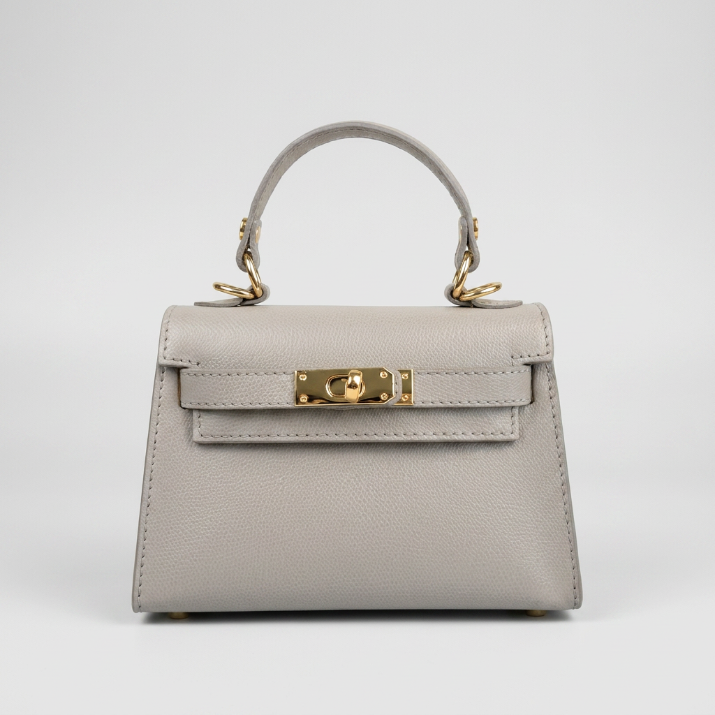 The Mini Kelly-Inspired Epsom Leather Handbag by Clemés in Silver, three-quarter studio shot on grey background