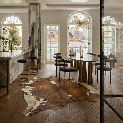 Caramel and ivory exotic printed cowhide rug styled on the floor of an editorial interior