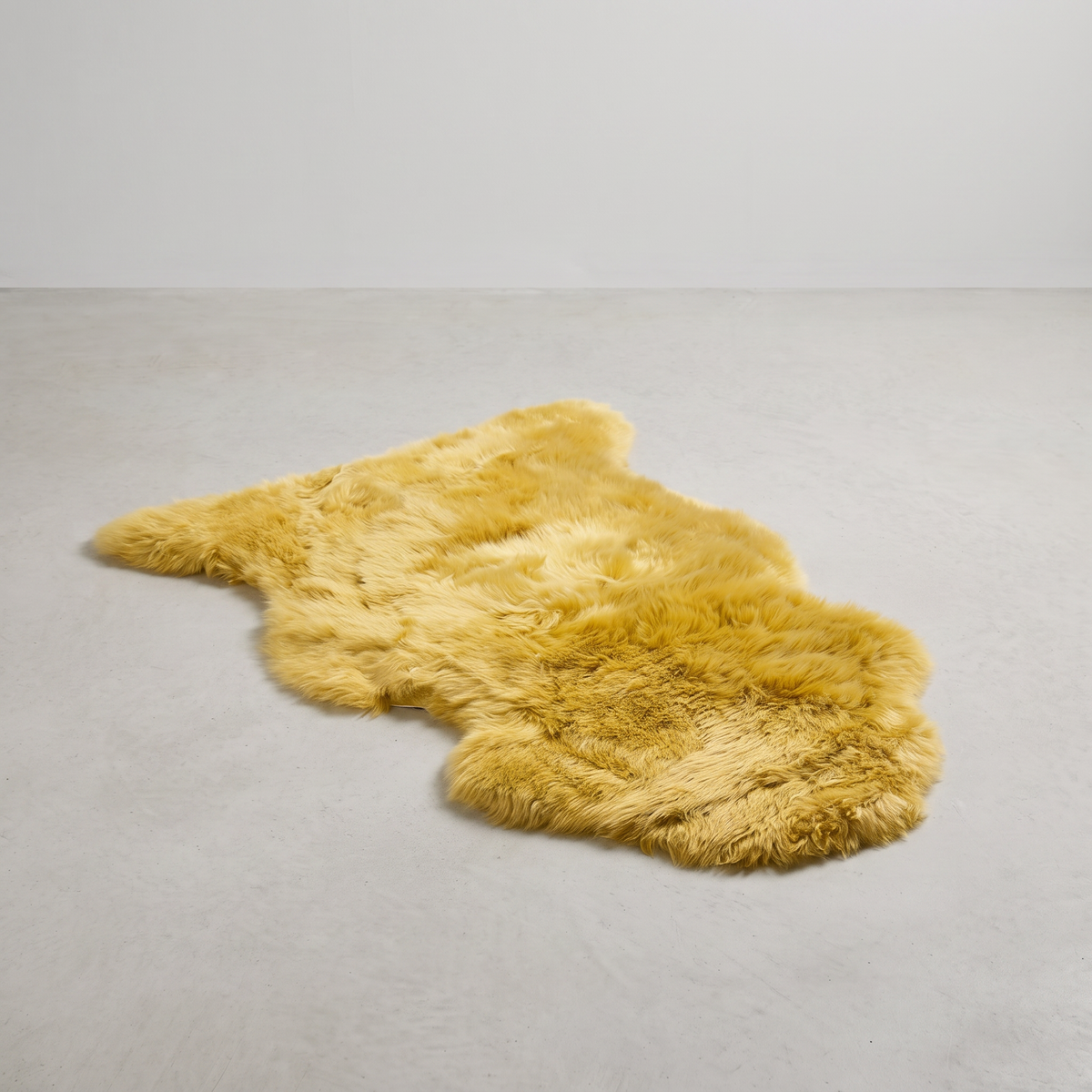 Squash single sheepskin rug laid flat on a pale grey floor
