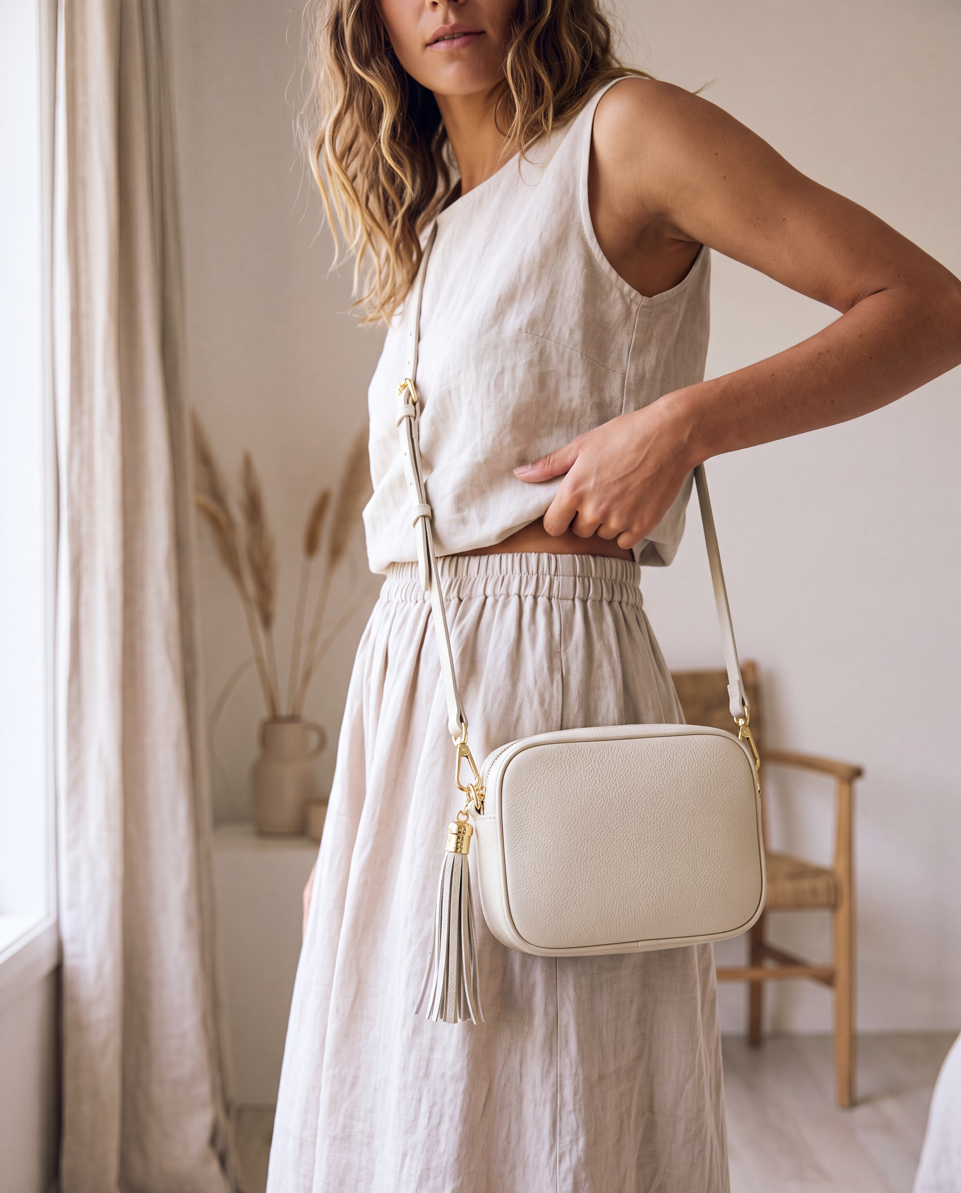 Model with the Ivory Éloise Leather Tassel Camera Bag by Clemés in a soft airy interior