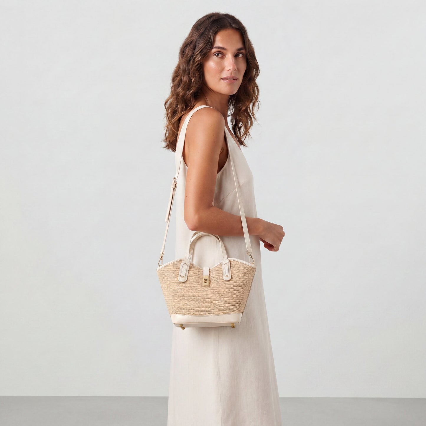 Model wearing the Oyster Sorrento Raffia & Leather Tote crossbody with the detachable strap, studio shot