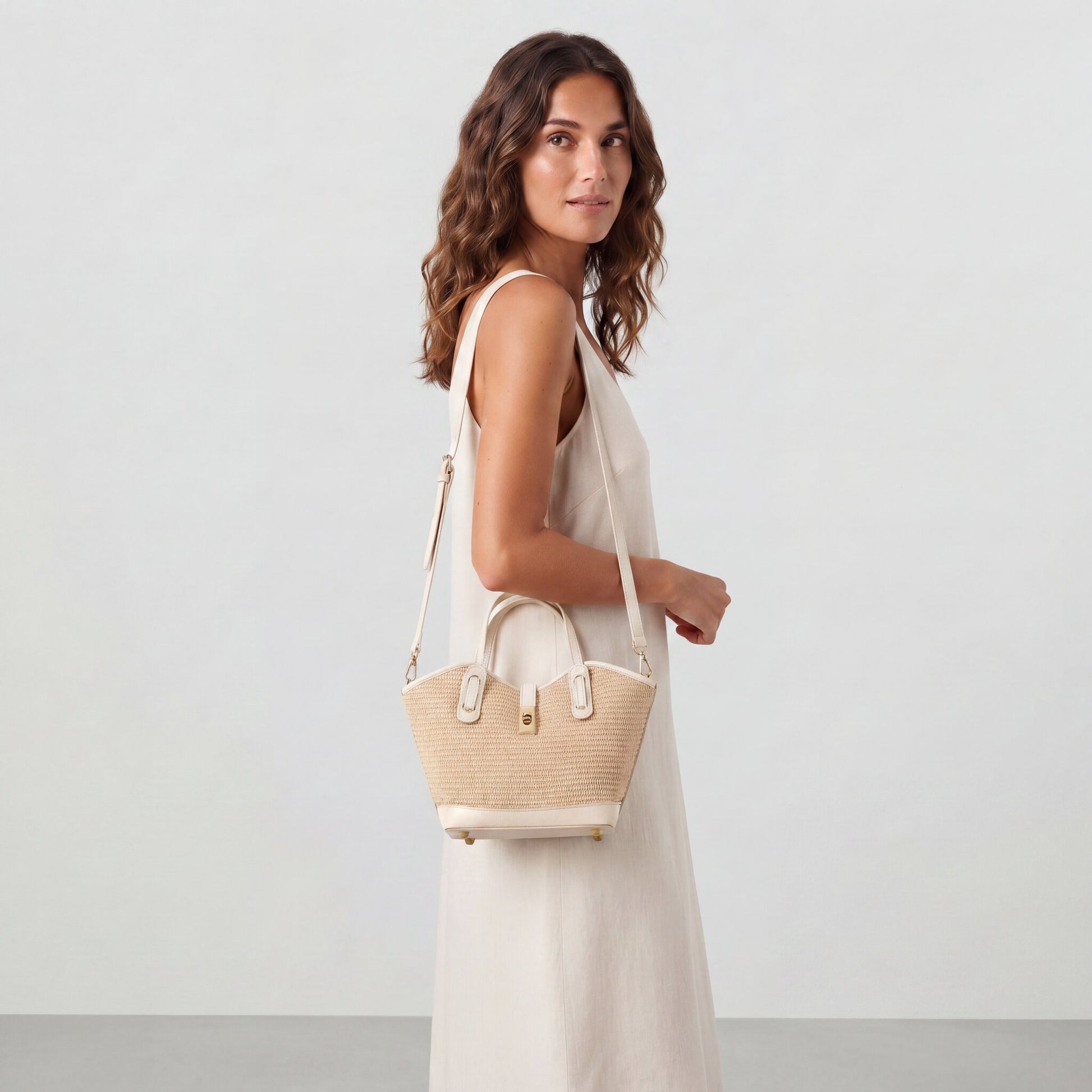 Model wearing the Oyster Sorrento Raffia & Leather Tote crossbody with the detachable strap, studio shot