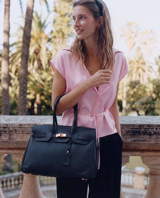 Woman on a sunlit terrace with the Black Valentina Maxi Leather Tote