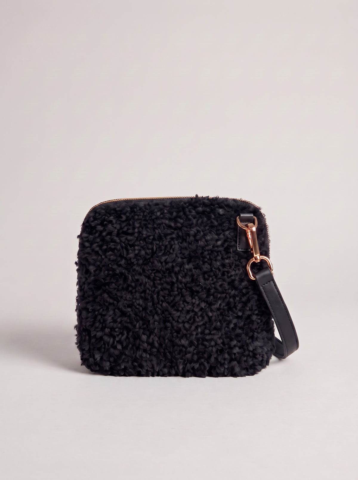 Zita faux shearling crossbody bag in black on a light grey studio background